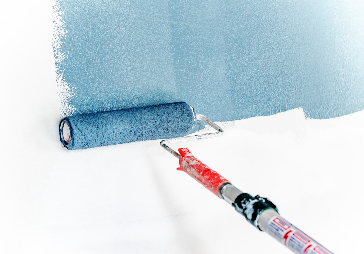 Detalle de rodillo aplicando pintura azul